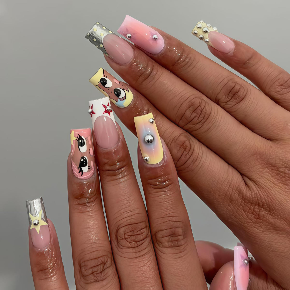 Cartoon Eye Nails with Red Stars, Pastel Pink and Yellow Accents, Silver-Toned Beads