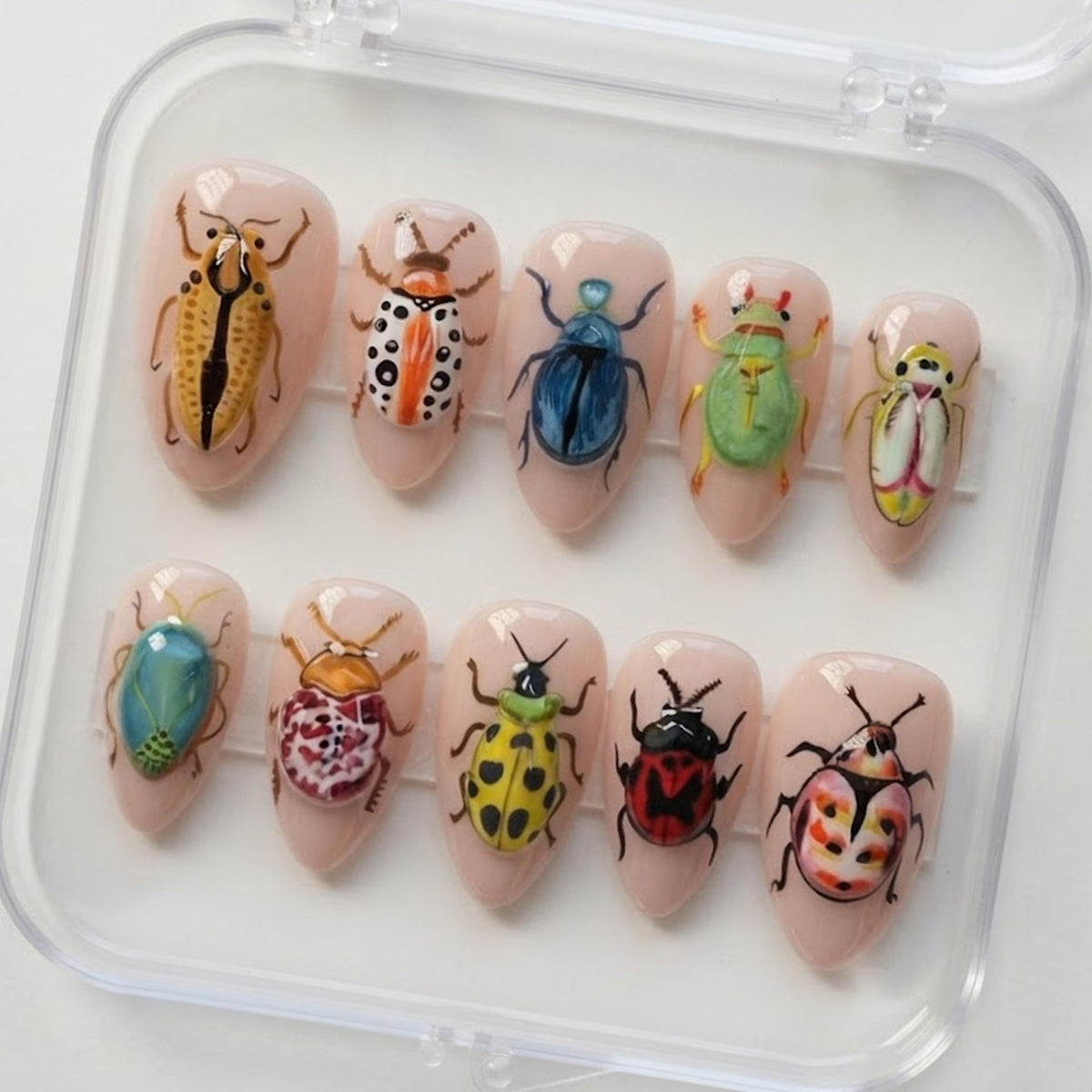 Colorful Beetle and Insect Press-On Nails on a Sheer Nude-Pink Base