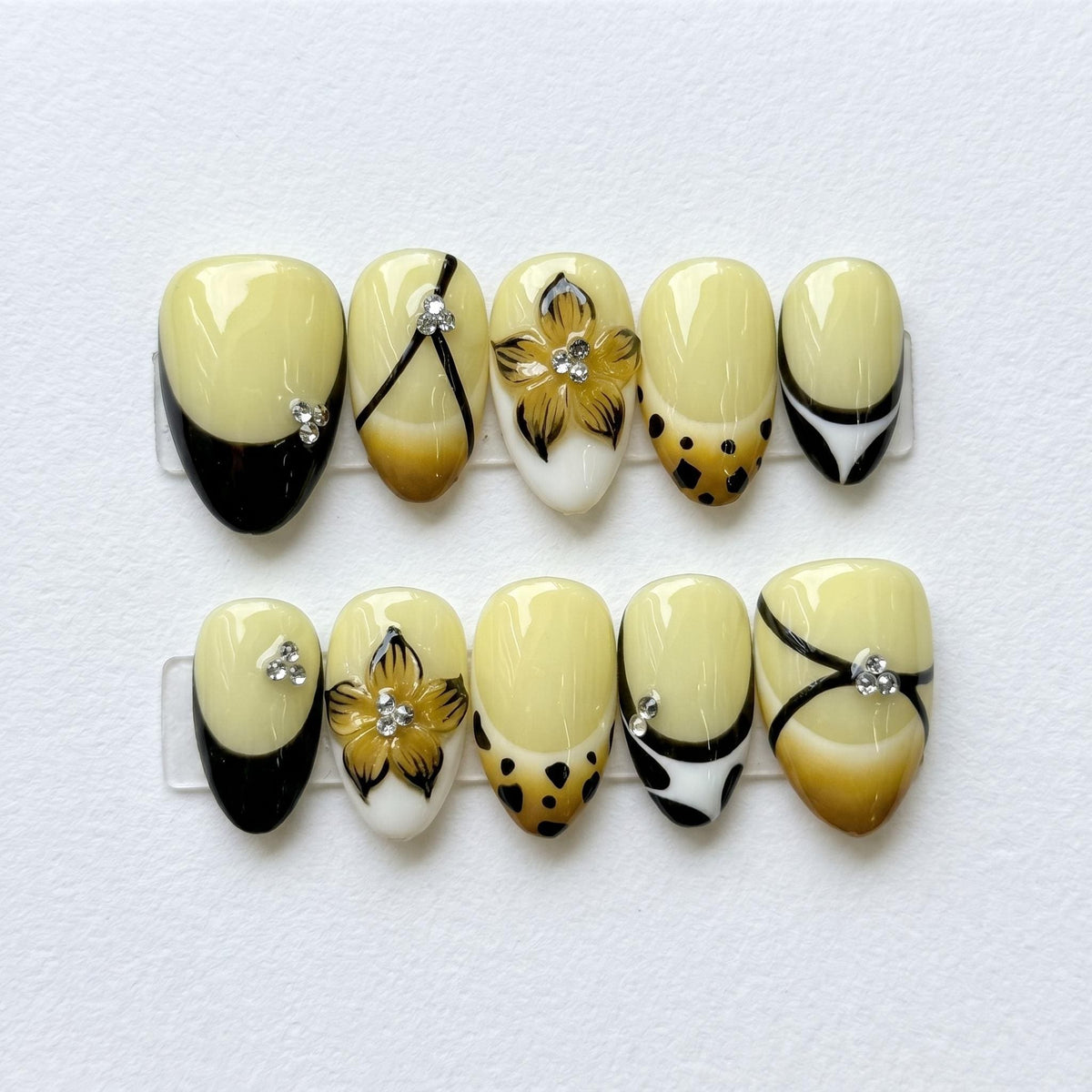 Cream and Black French Tip Nails with Floral Rhinestones and Spotted Amber Details