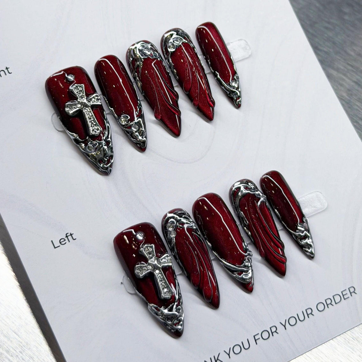 Dark Angel Glossy Deep Red Nails With Silver Cross Charms and Chrome Baroque Details