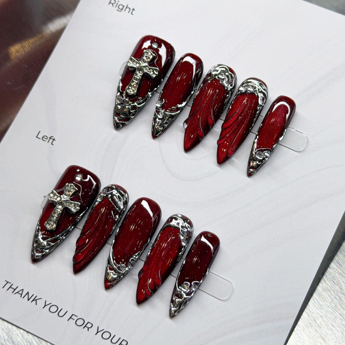 Dark Angel Glossy Deep Red Nails With Silver Cross Charms and Chrome Baroque Details