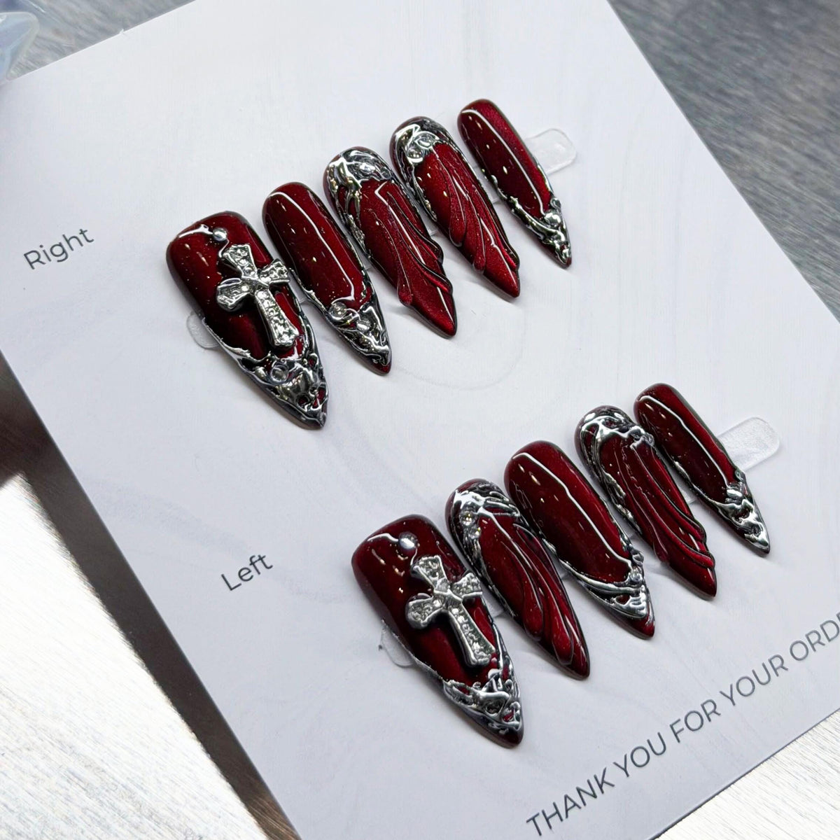 Dark Angel Glossy Deep Red Nails With Silver Cross Charms and Chrome Baroque Details
