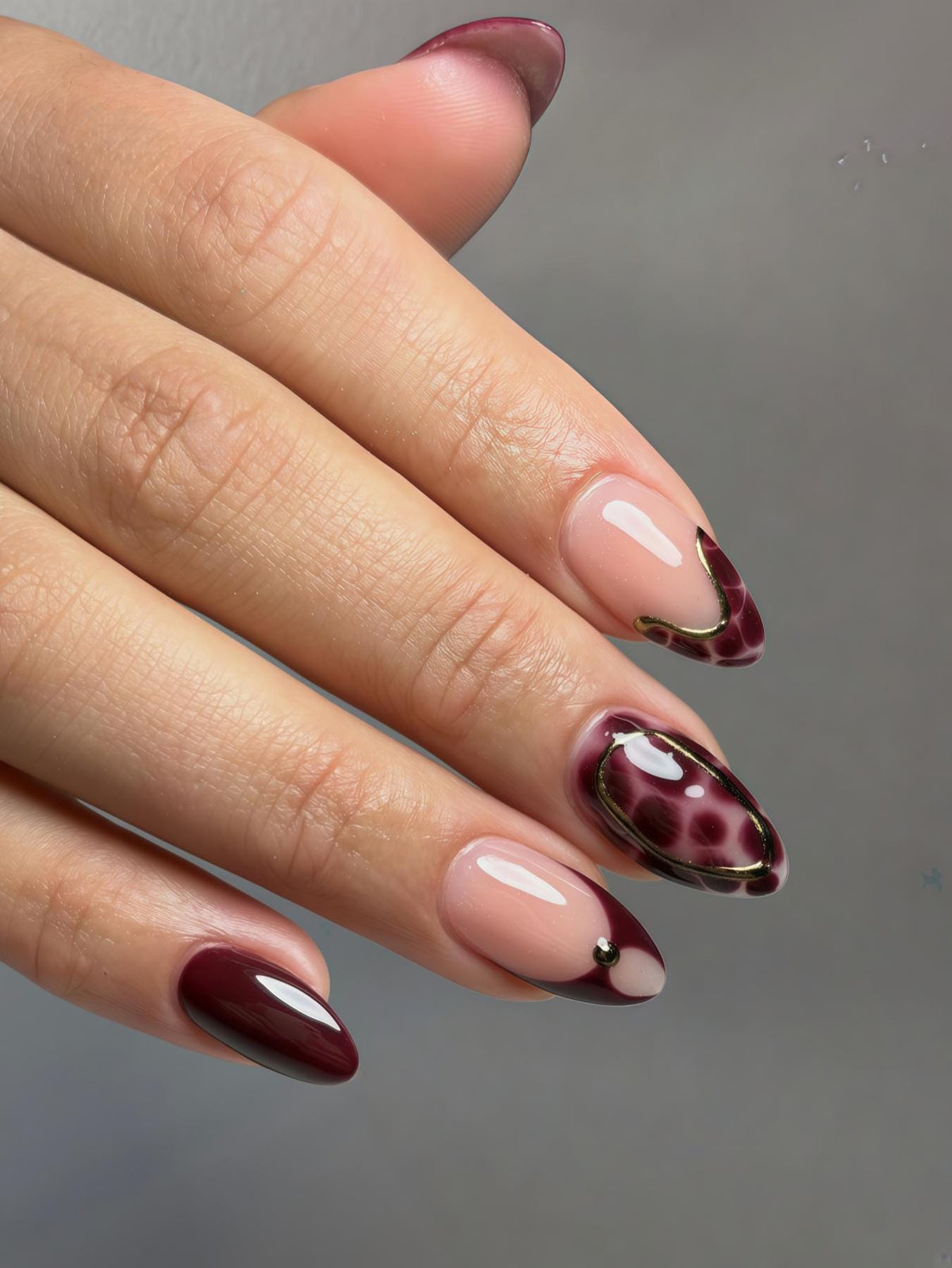 Deep Burgundy French Tip Nails with Leopard Print and Gold-Toned Accents