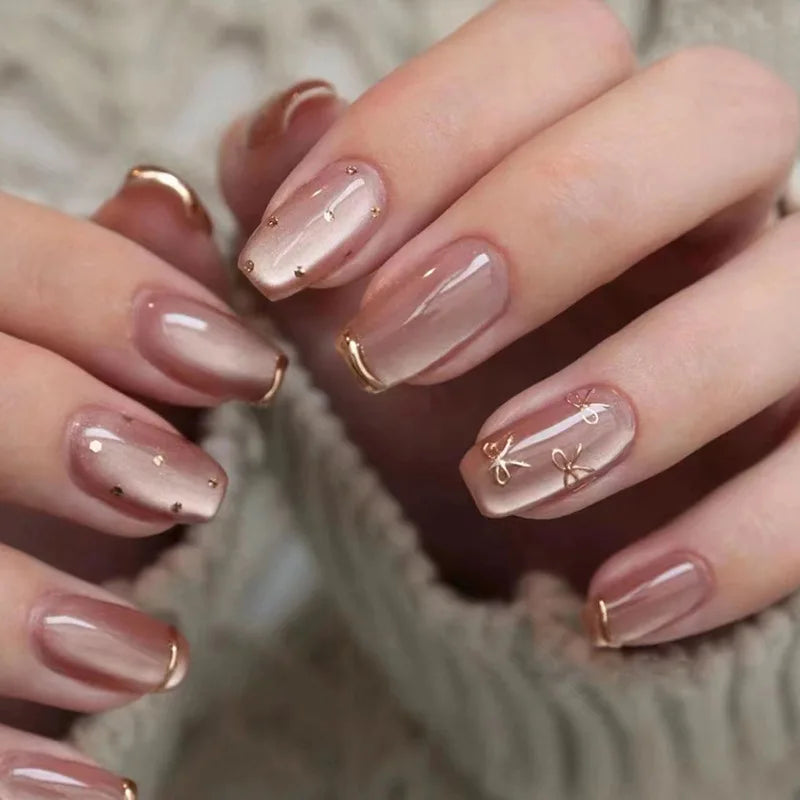 Dusty Mauve Shimmer Nails with Gold Bows and Curved French Tips