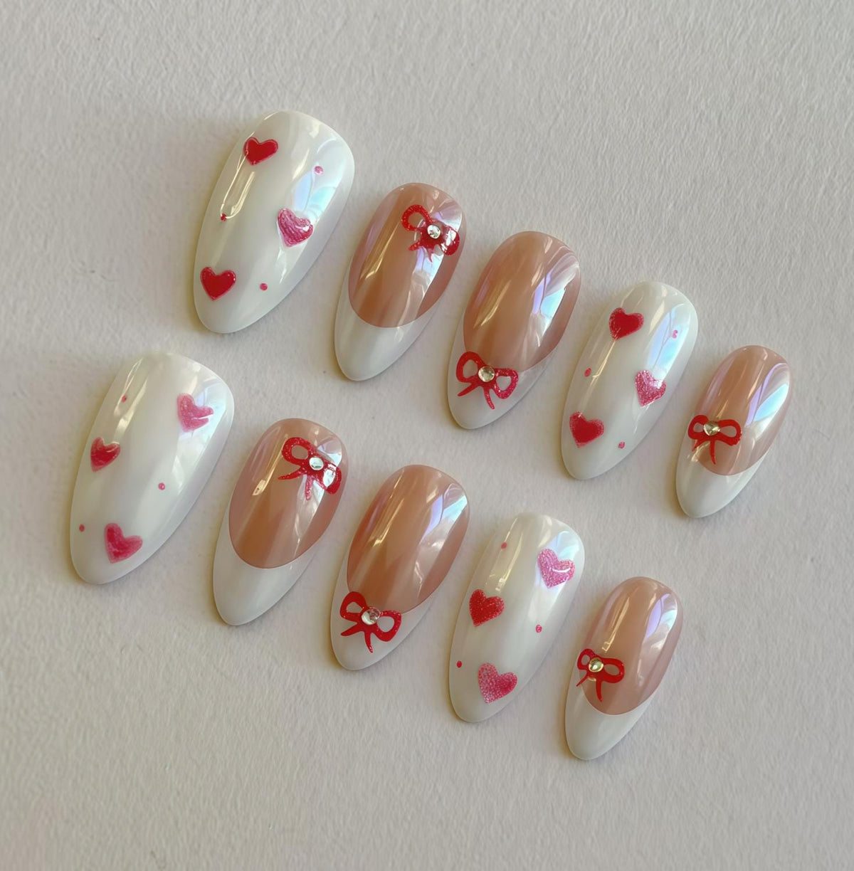 Iridescent French Tip Nails with Red Bows, Hearts, and Rhinestones