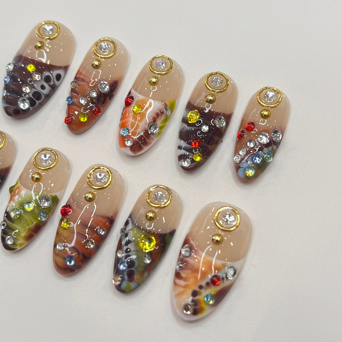 Marbled Swirl Press-On Nails with Gold-Rimmed Stones and Colorful Rhinestones