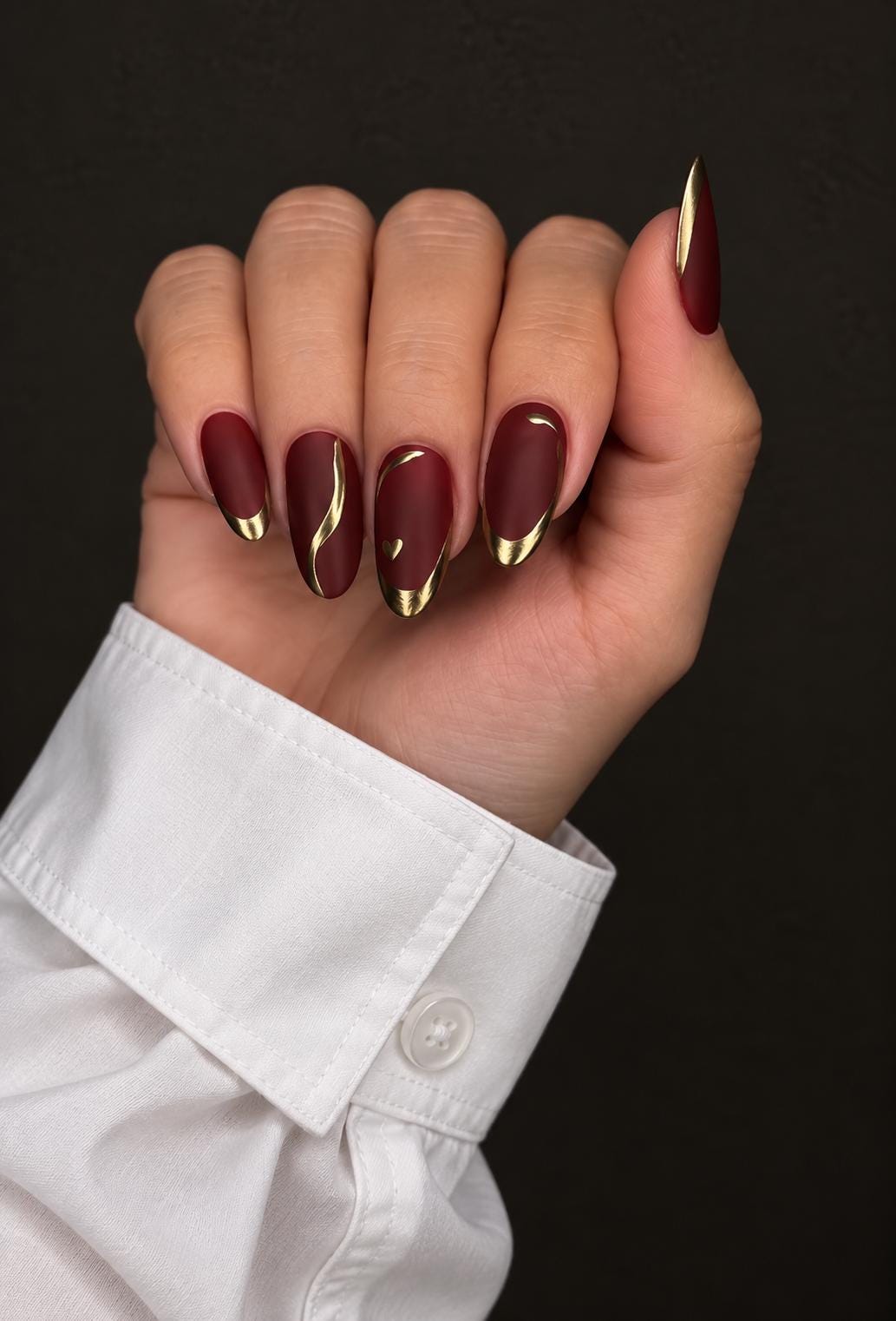 Matte Burgundy Nails With Curved Gold Accents and Metallic Tips for Fall and Winter