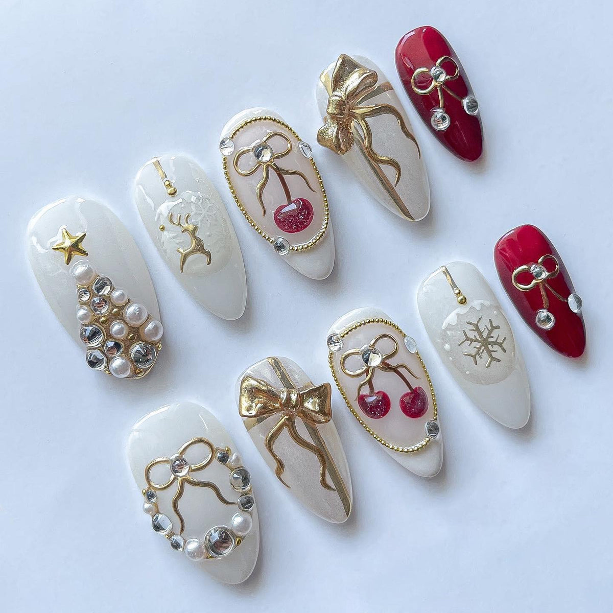 Milky White Christmas Nails With Pearl Trees, Gold Bows, Cherries, and Reindeer