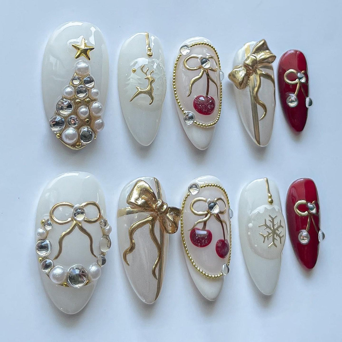 Milky White Christmas Nails With Pearl Trees, Gold Bows, Cherries, and Reindeer
