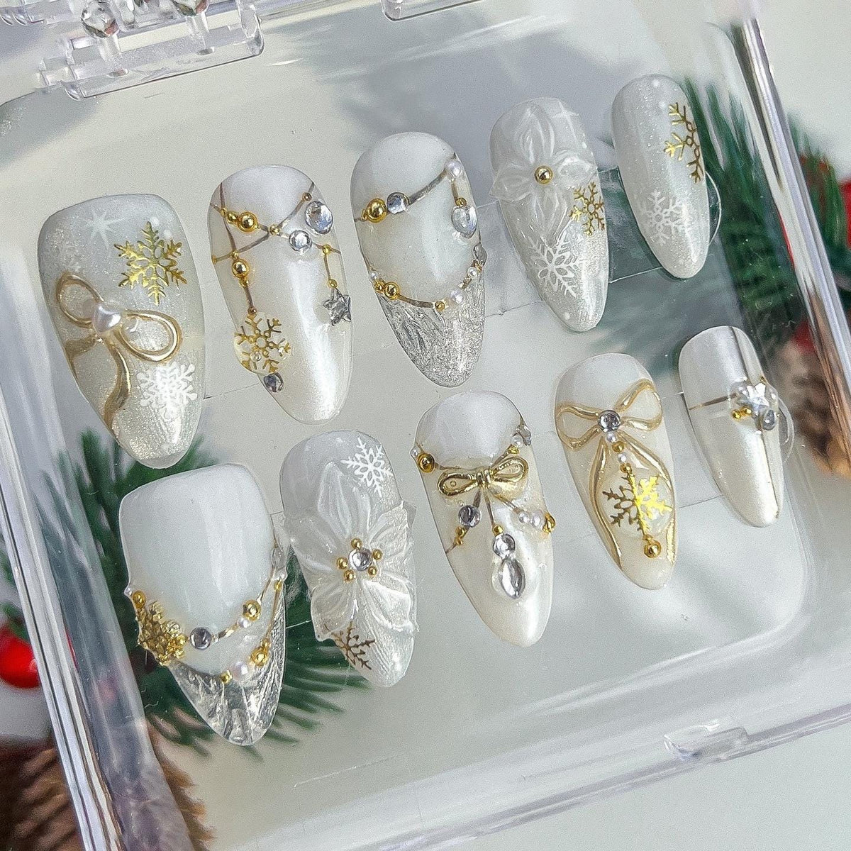 Milky White Christmas Snowflake Nails With Gold Bows, Rhinestones and Charms