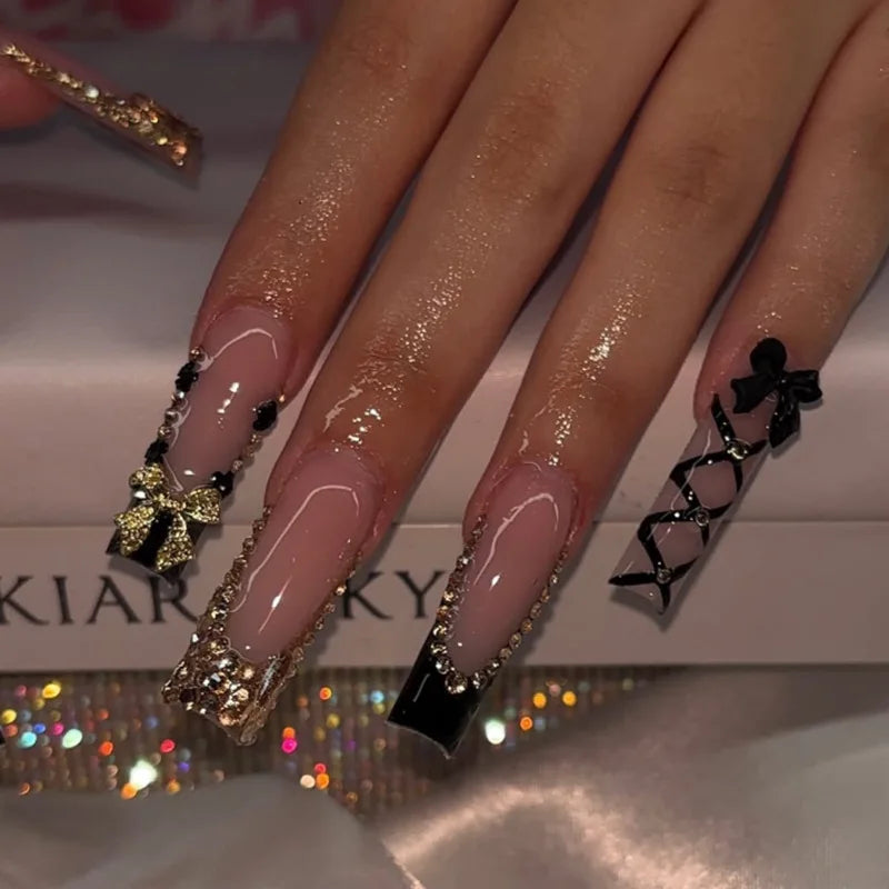Nude and Black Gothic Nails with Gold Rhinestones and Bow Details