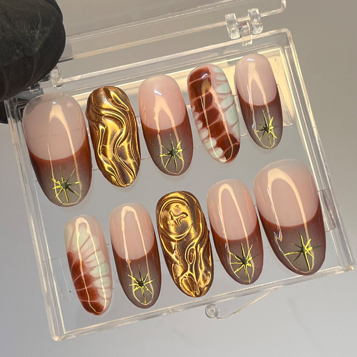 Nude Pink and Brown French Tip Nails with Gold Starbursts and Marble Details