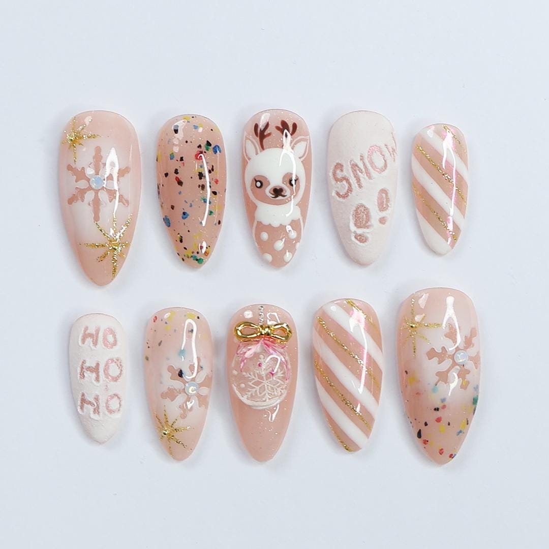Nude Pink Christmas Nails With Reindeer, Snowflakes, Gold Glitter and Bow Charm