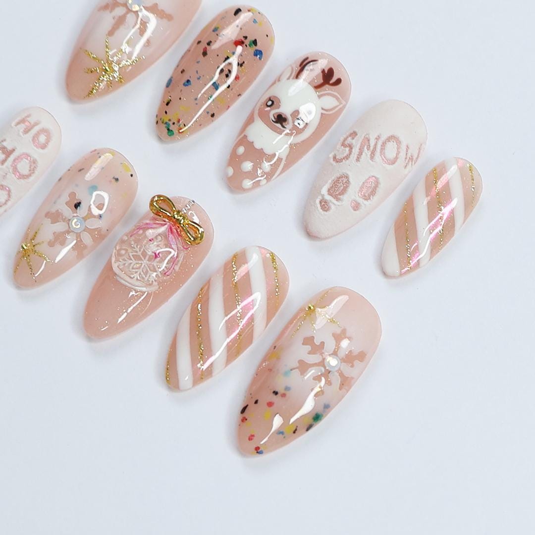 Nude Pink Christmas Nails With Reindeer, Snowflakes, Gold Glitter and Bow Charm