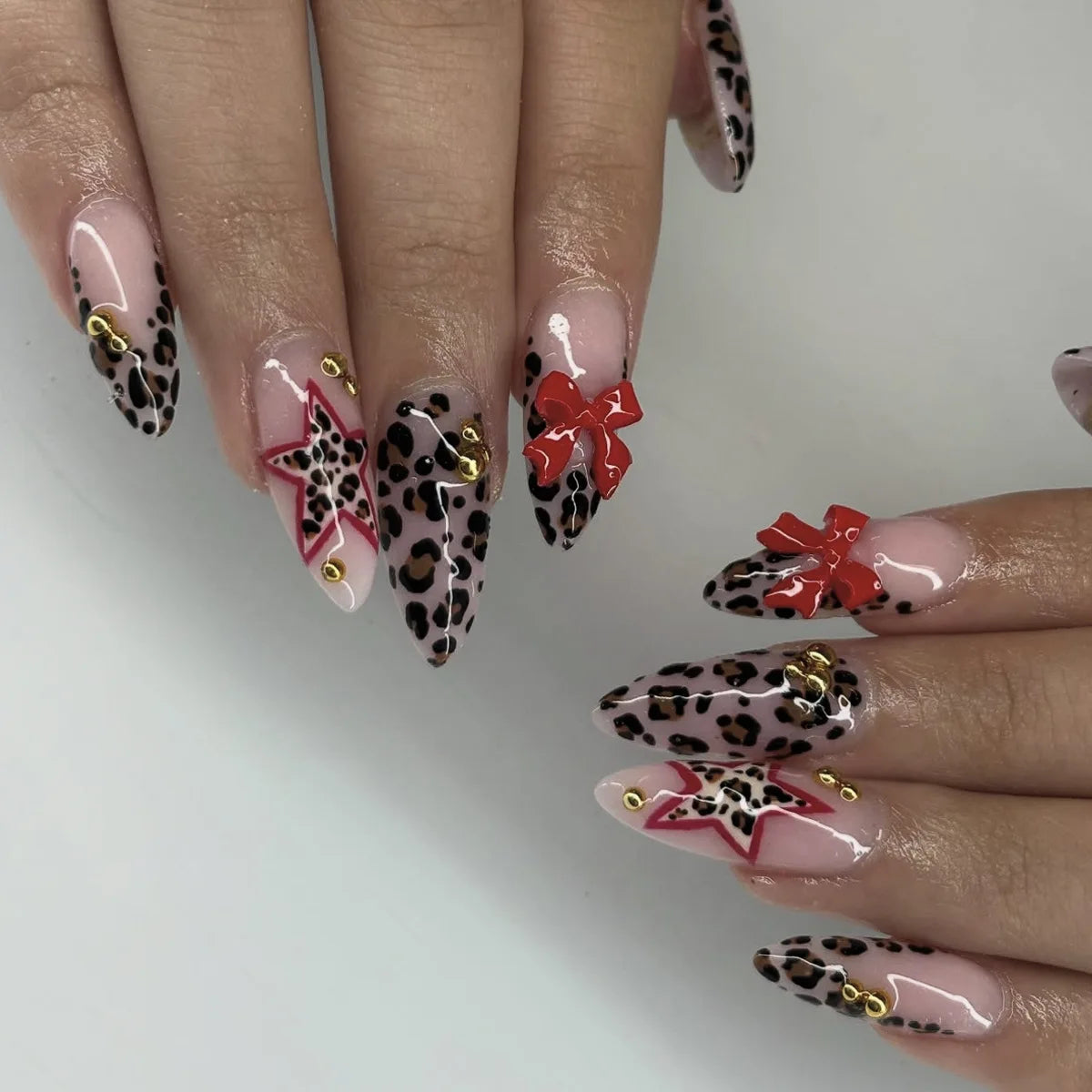 Nude Pink Leopard French Tip Nails With Red Bows and Star Accents