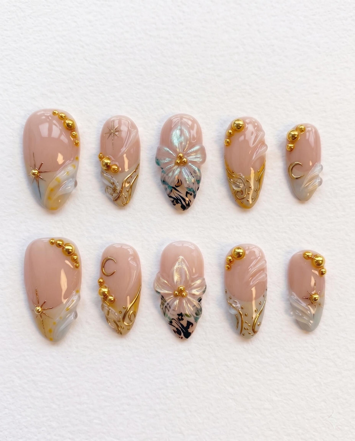 Nude Pink Shell-Inspired Nails with Blue Floral Art and Gold Details
