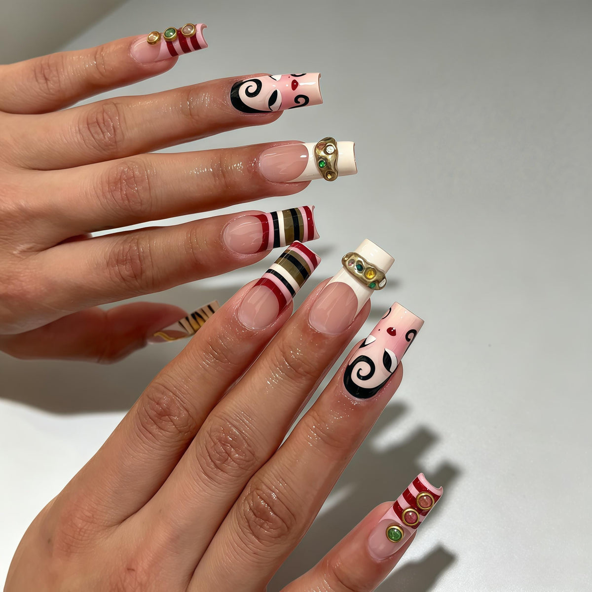 Opera-Inspired Pink Swirl Nails with Stripes and Jeweled Gold Charms