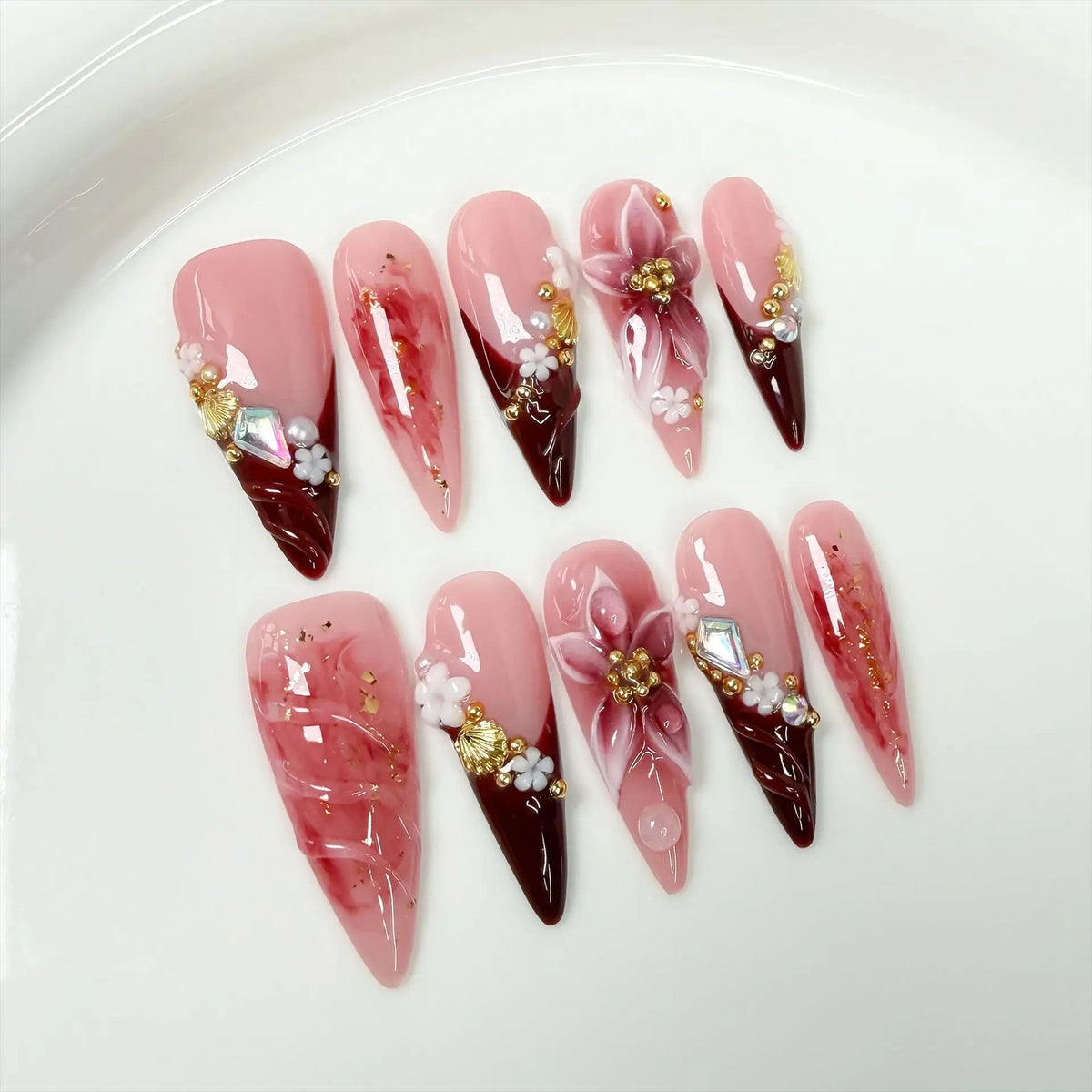 Pink and Burgundy Floral Nails with Gold Accents and Rhinestone Charms