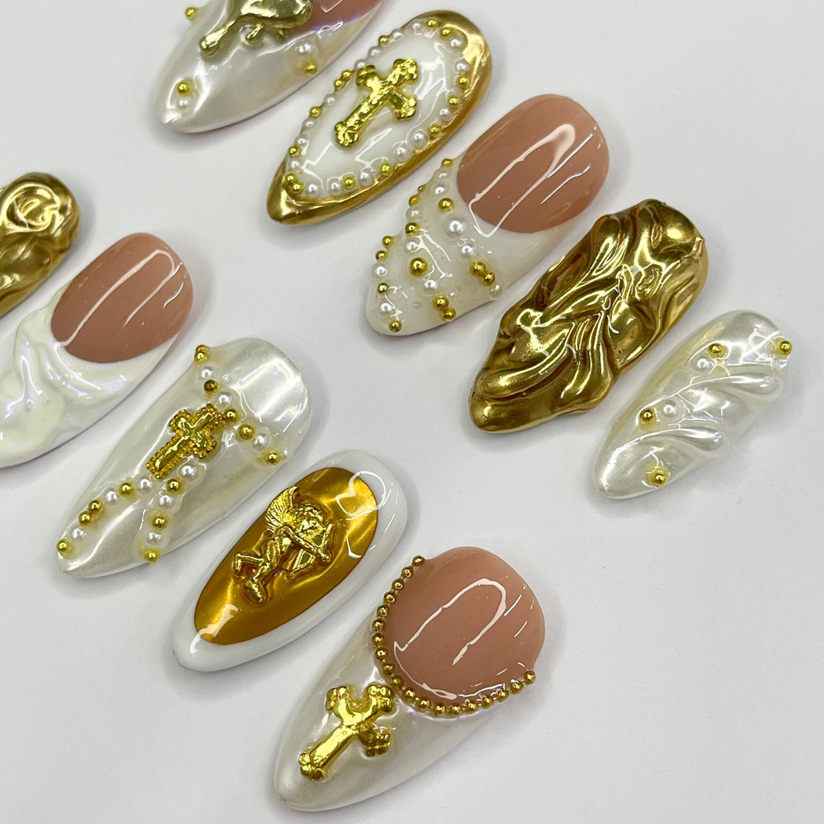 Cupid-Inspired Nude and Ivory French Tip Nails with Gold Crosses and Baroque Accents