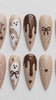 Neutral Brown Halloween Nails With Ghosts, Spiderwebs, Bows, and Jack-O’-Lantern Faces