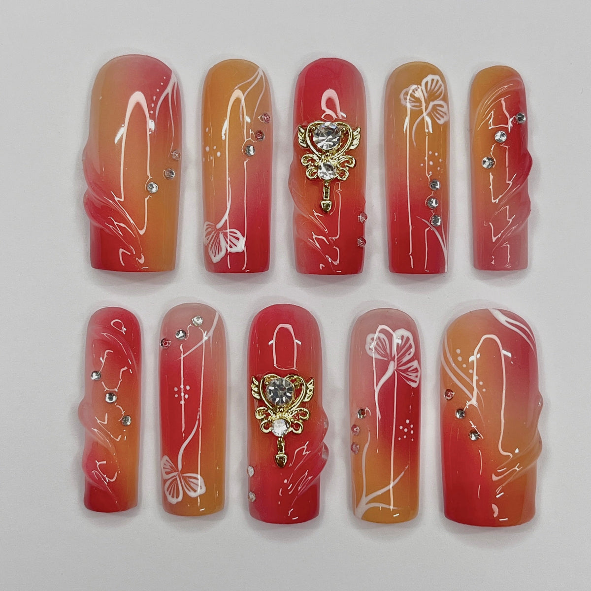 Red, Coral and Orange Gradient Nail Set with White Line Art and Crystal Charms