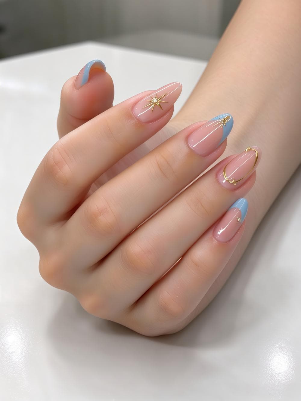 Sheer Blush Pink French Tip Nail Set with Light Blue Tips and Gold Starbursts