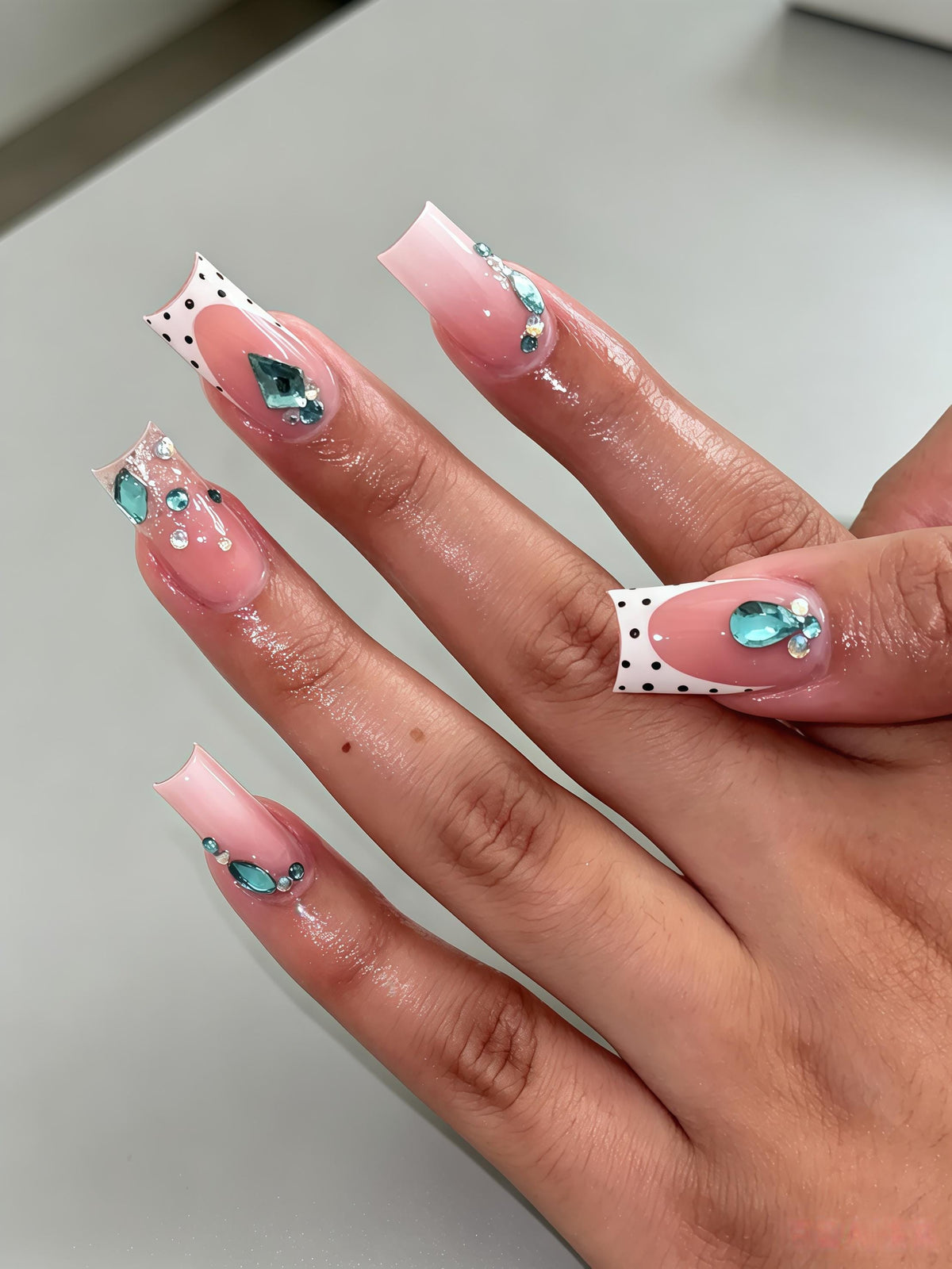 Sheer Nude Pink French Tip Nails With Black Polka Dots and Teal Rhinestones