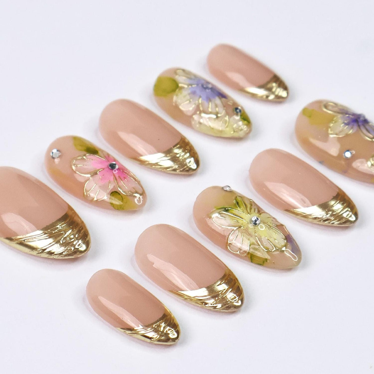 Spring Floral Nails With Nude Pink Base, Gold French Tips, and Rhinestone Accents