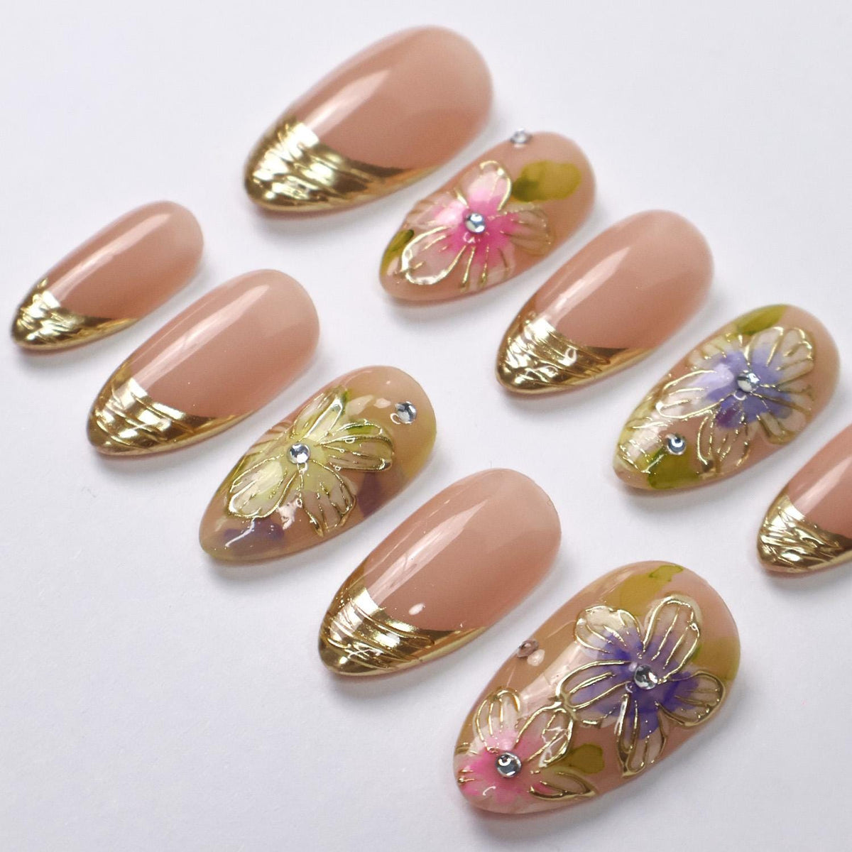 Spring Floral Nails With Nude Pink Base, Gold French Tips, and Rhinestone Accents